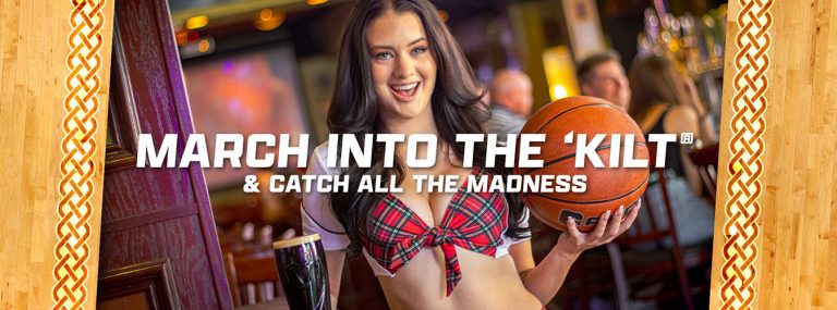 March into the Kilt - girl in tilted kilt uniform holding a beer and a basketball